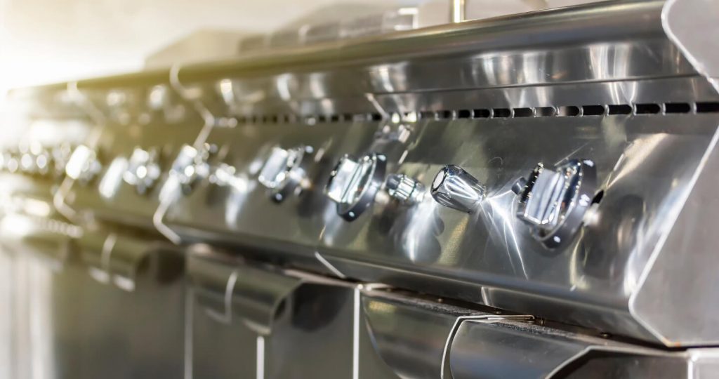 line of gas stoves in commercial kitchen